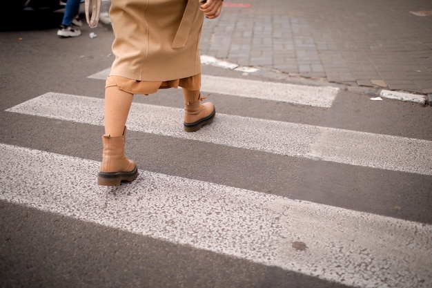 a woman crosses the road at a pedestrian crossing. woman in the city