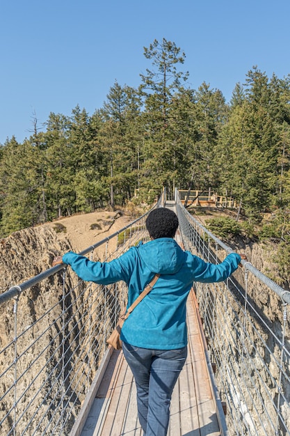 Woman crossing suspension bridge and conquering her fear
