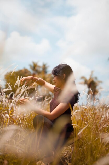 Photo woman crouching by plants against sky