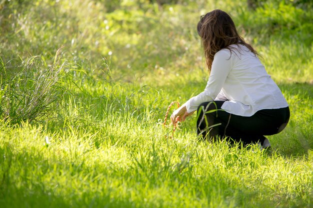Photo woman crouching on grassy field
