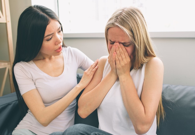 泣いている女性と彼女の友人は彼女を安心させる