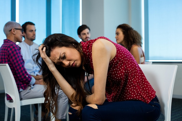 woman crying while creative business team behind at office