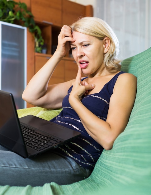 Woman crying while using laptop