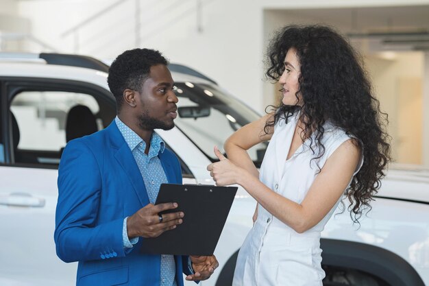 Woman customer enjoys african american salesman car offer