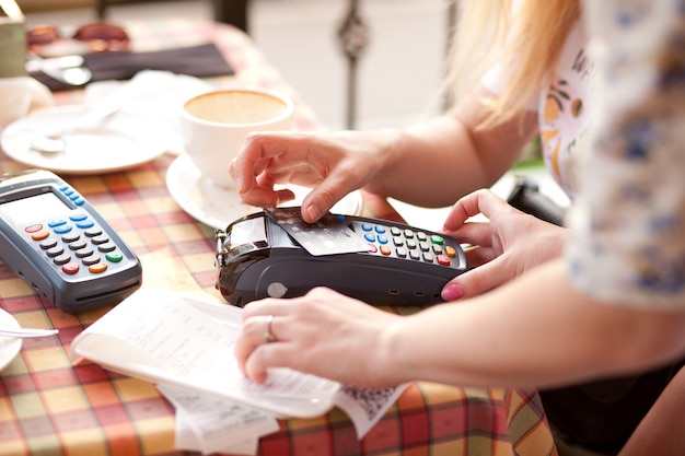 Женщина-клиент, оплачивающая кредитной картой в кафе