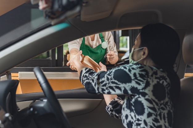 Woman customer pick up food at drive through