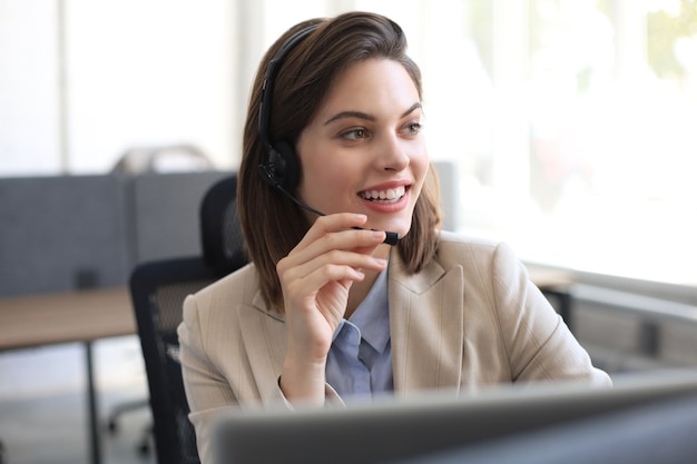 Woman customer support operator with headset and smiling.