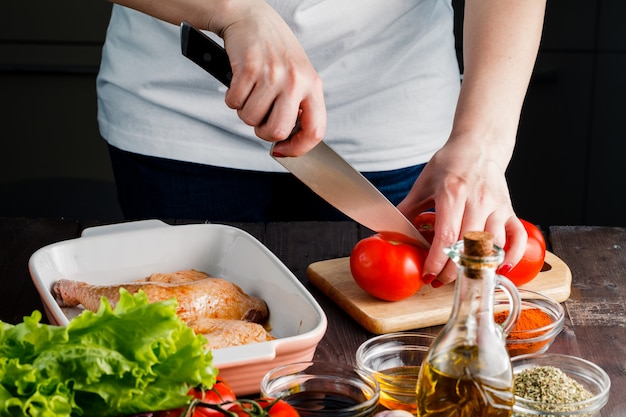 Foto pomodoro tagliato donna per cucinare pollo