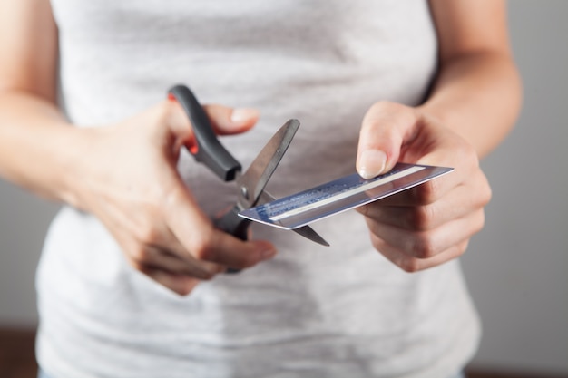 Woman cuts a bank card with scissors