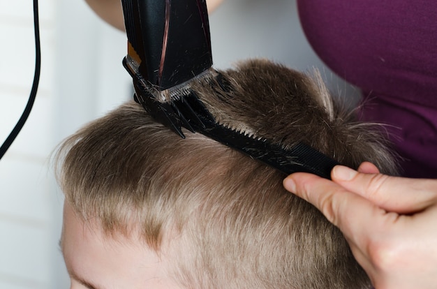 Woman cuts hair of boy at home. Home haircut.