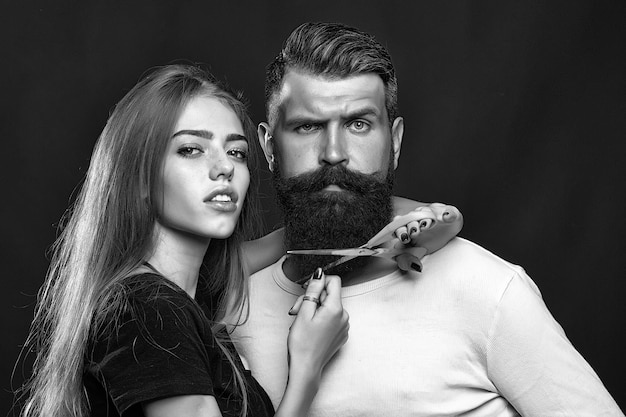 Woman cuttin male beard