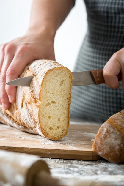 Woman cutting bread on wooden table