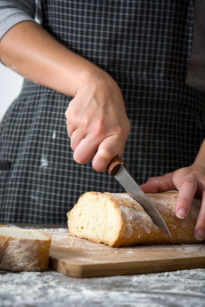 Woman cutting bread on wooden table