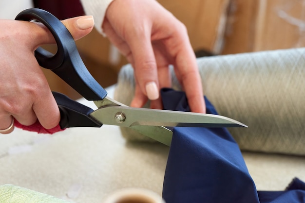 Woman cutting fabric with scissors