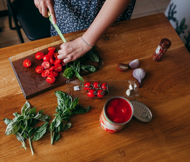 Woman cutting fresh vegetables on the kitchen table 