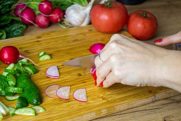 Woman cutting harvested vegetables Tomatoes cucumbers peppers parsley zucchini leeks garlic