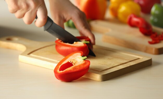 Woman cutting pepper in kitchen