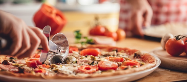 Photo woman cutting pizza