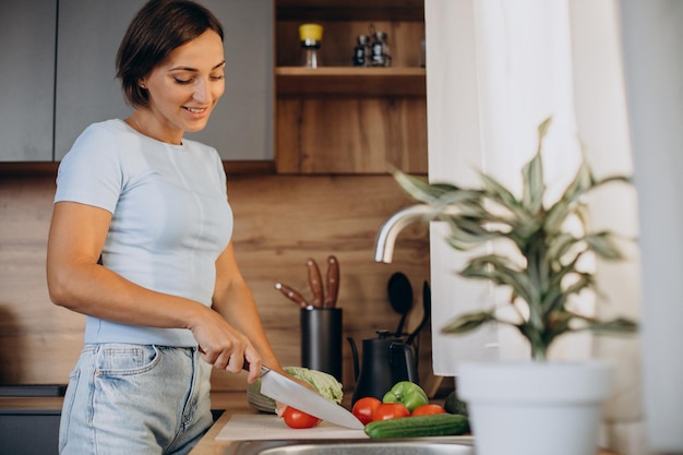 Woman cutting vegetables at the kitchen