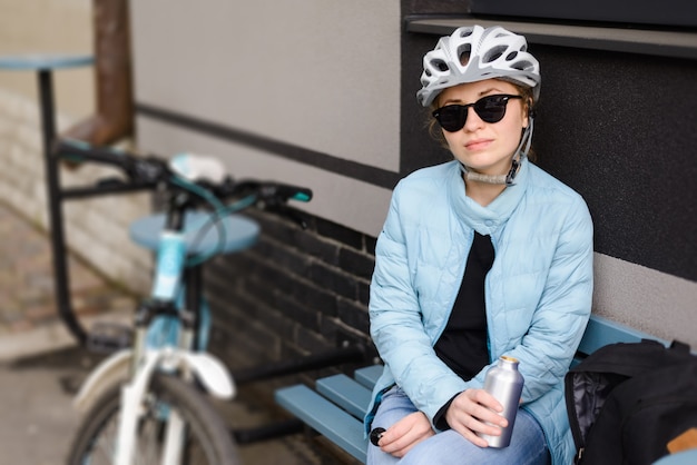 Woman cyclist in a helmet and sunglasses