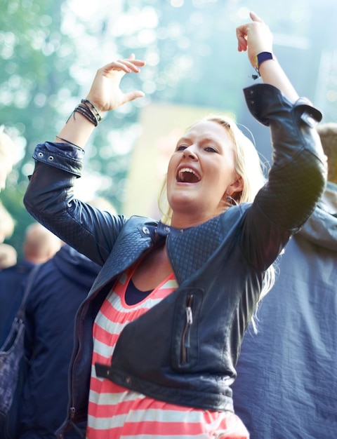 Foto donna che balla e applaude all'aperto al festival musicale per la libertà, esibizione e intrattenimento con la folla, persona felice o che grida a un concerto o a uno spettacolo con il pubblico in natura per una festa estiva.