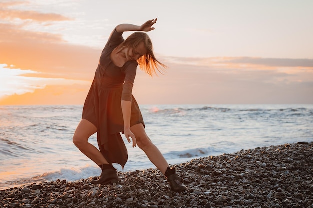 Foto la donna balla in riva al mare al tramonto psicologia dell'anima e del corpo danza grazia