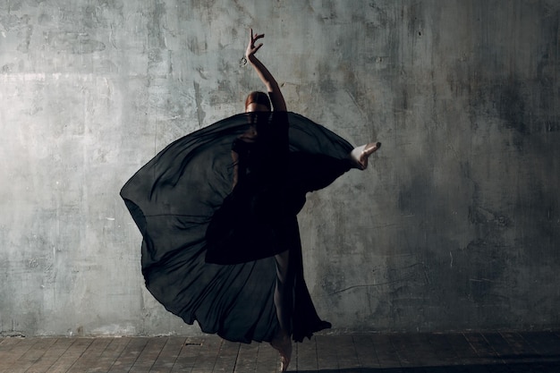 woman dancing against gray wall