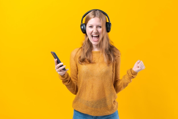 Woman dancing to music while listening to mp3 player with wired headphones