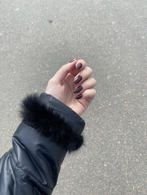 Woman dark nail design on a grey background