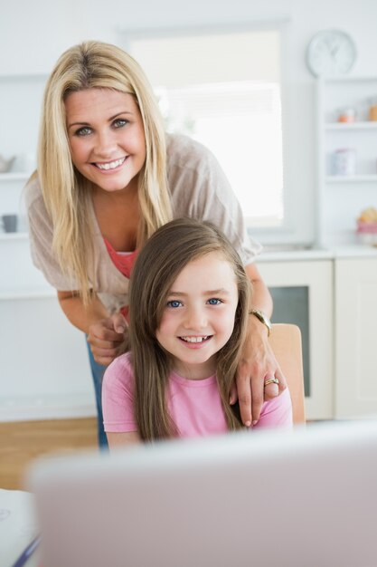 Woman and daughter smiling at the laptop