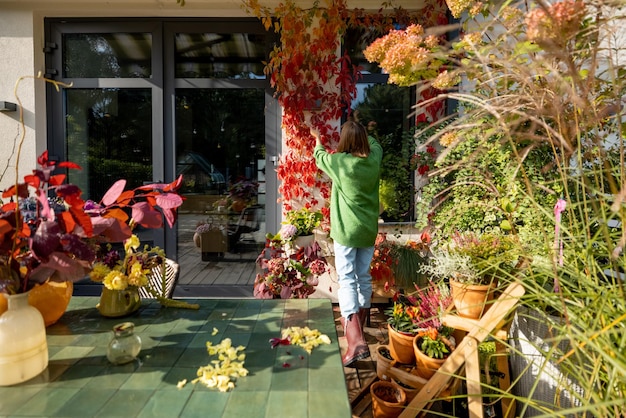 Woman decorates a beautiful facade with wild ivy on it