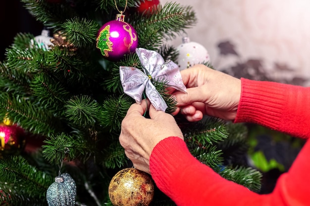 A woman decorates a Christmas tree the atmosphere of the holiday