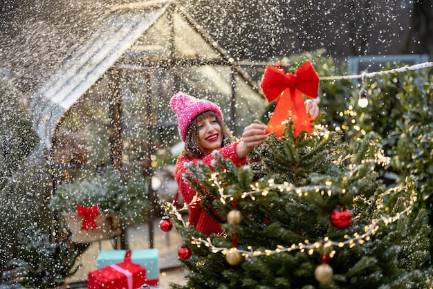 Woman decorates christmas tree at backyard