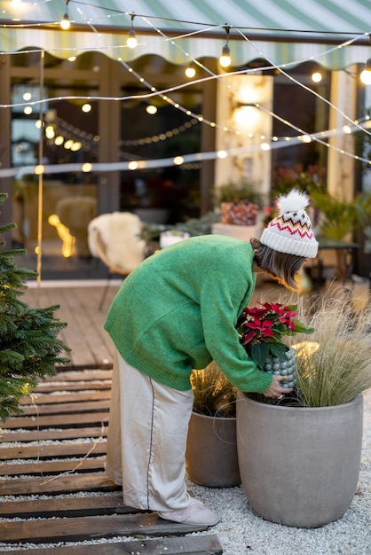 Woman decorates her yard for the new year holidays