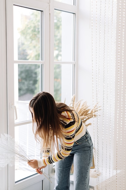 Woman decorating bright living room before the holidays.