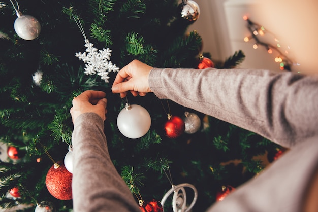 Donna che decora un albero di natale