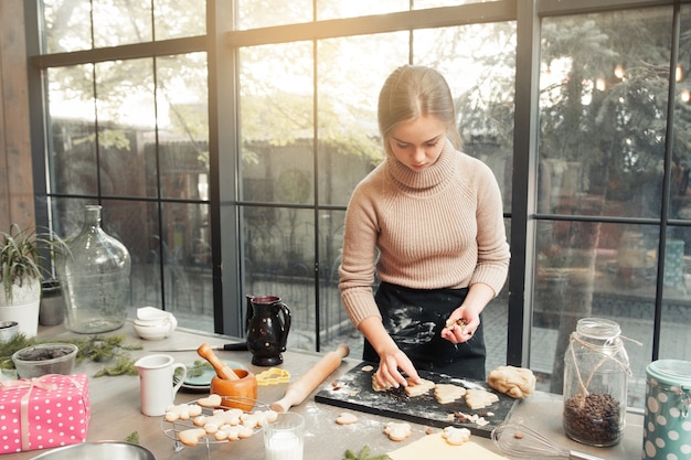 Женщина украшает печенье перед выпечкой