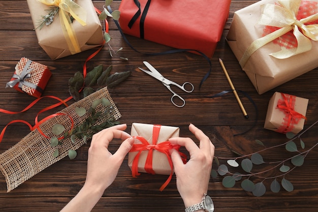 Woman decorating gift box on table