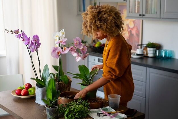 Photo woman decorating her home with orchids