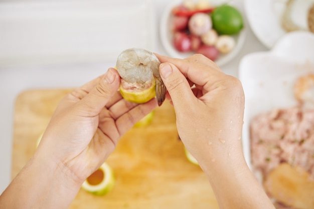 Woman decorating zuccini ring with shrimp