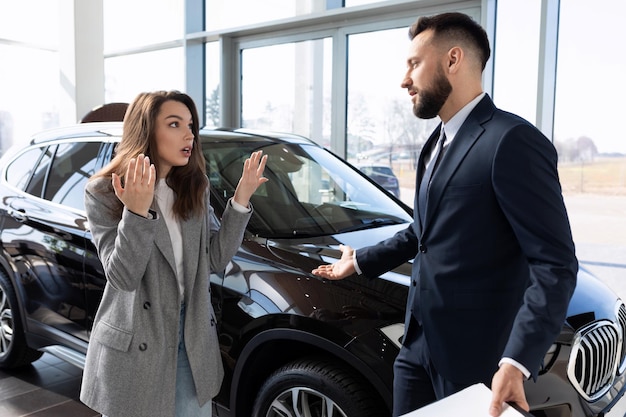 A woman defends her rights in a dealership arguing with a representative of a car dealership