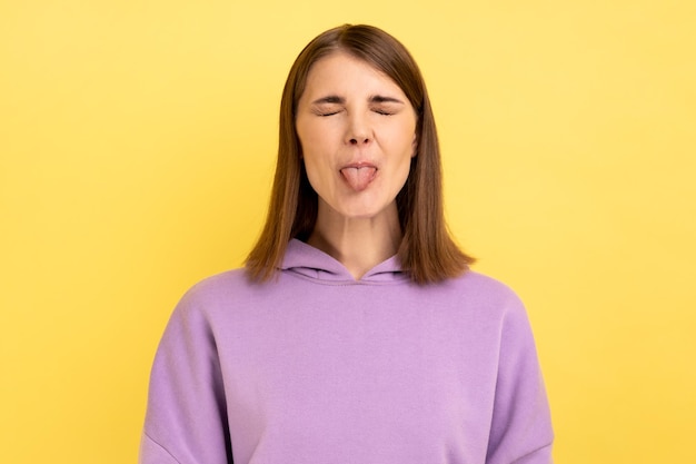 Woman demonstrating tongue behaving naughty unruly childish mood closed eyes