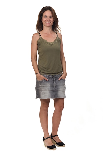 Woman in a denim skirt on white background, hands on pocket