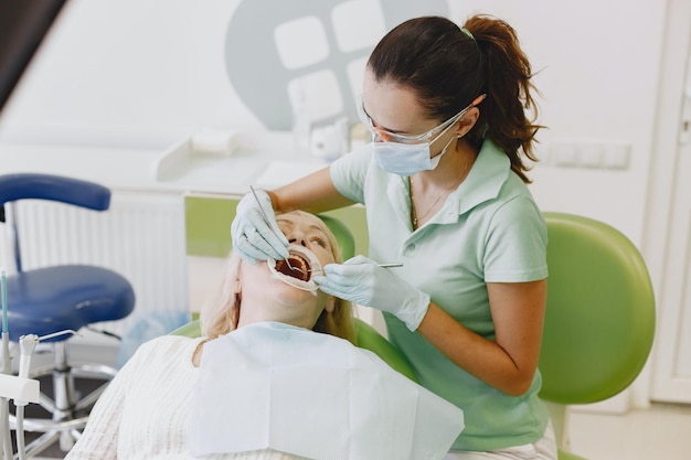 A woman in a dental chair with a dentist in her hand.