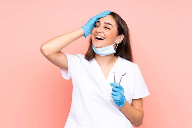 사진 분홍색 배경 웃음에 고립 된 도구를 들고 여자 치과 의사