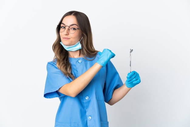 Woman dentist holding tools over isolated proud and self-satisfied