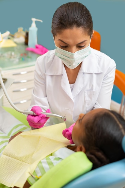 Woman dentist leaning over a female patient