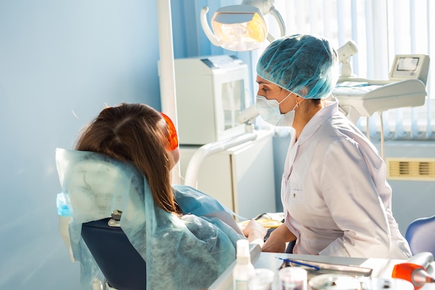 치과의사 사무실의 여성 치과의사는 환자를 치유합니다.