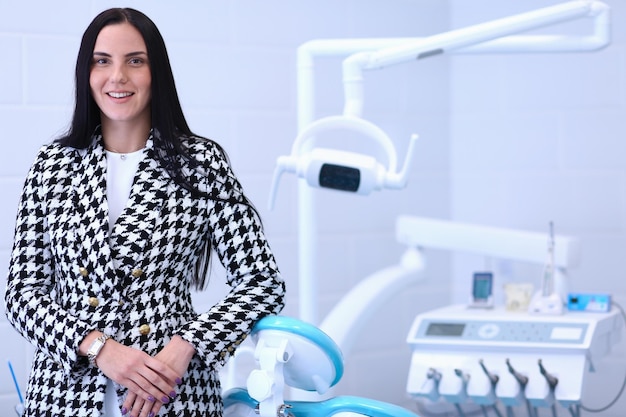 Woman dentist standing in her office smiling