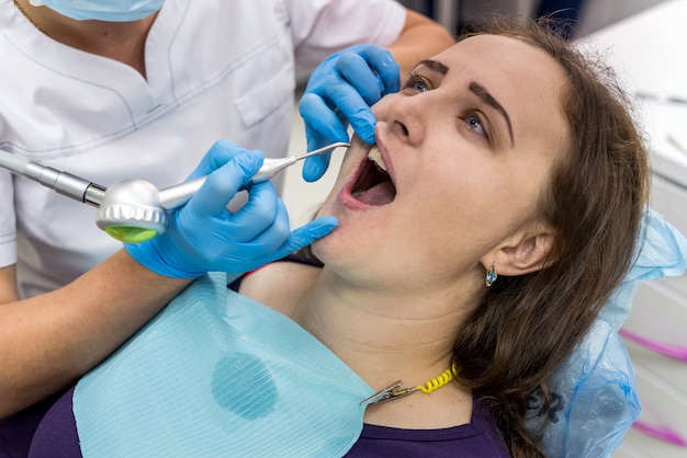 Woman in dentistry making hygiene of teeth